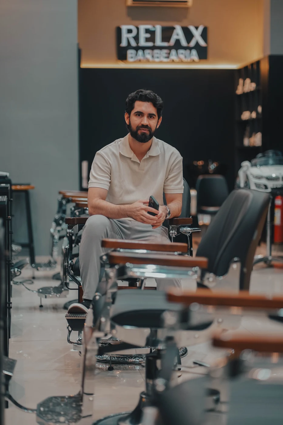 Lucas Rodrigues sentado em uma cadeira da Relax Barbearia